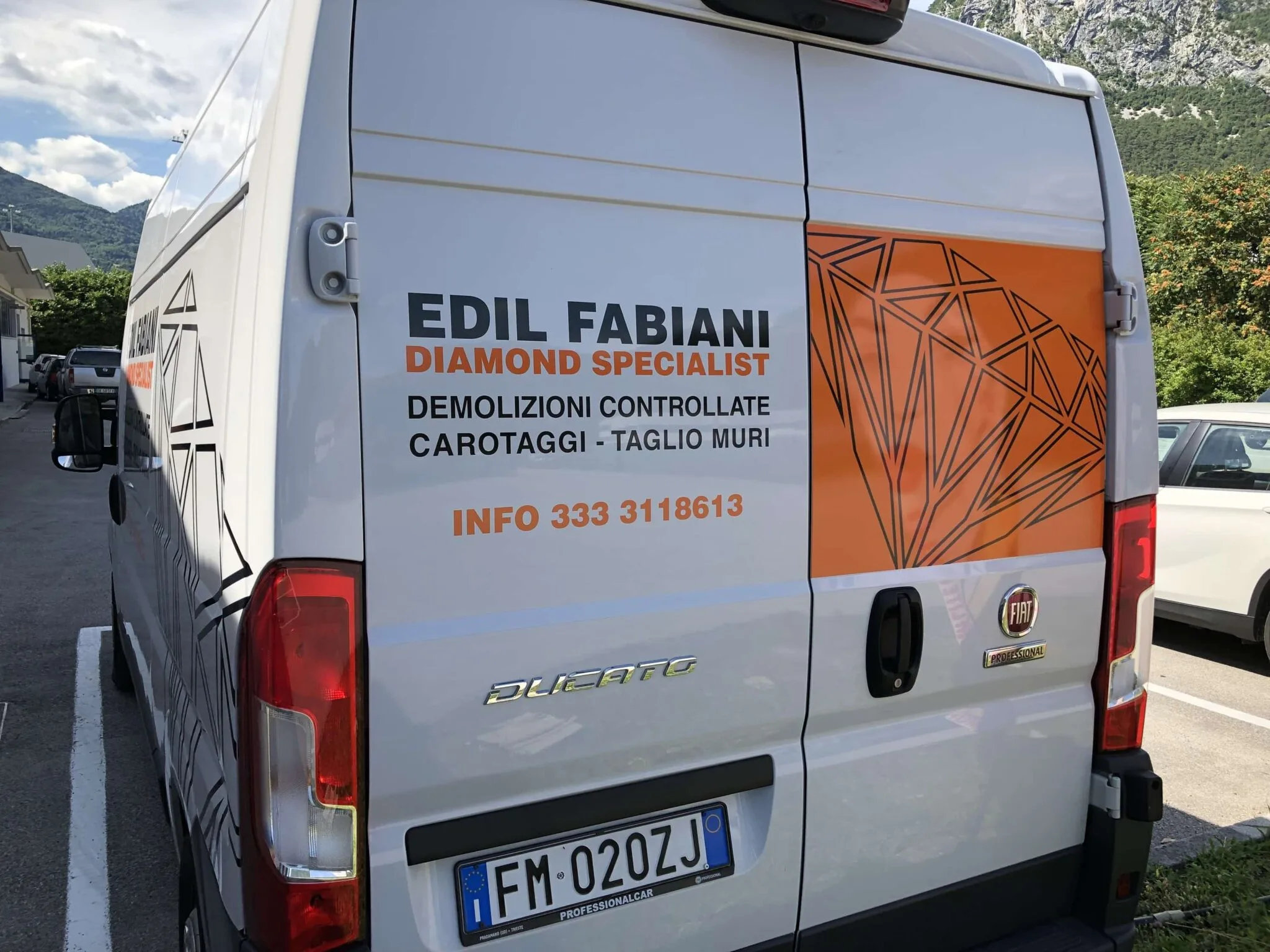 Retro del furgone Edil Fabiani con portellone arancione a diamante e scritte demolizioni e carotaggi