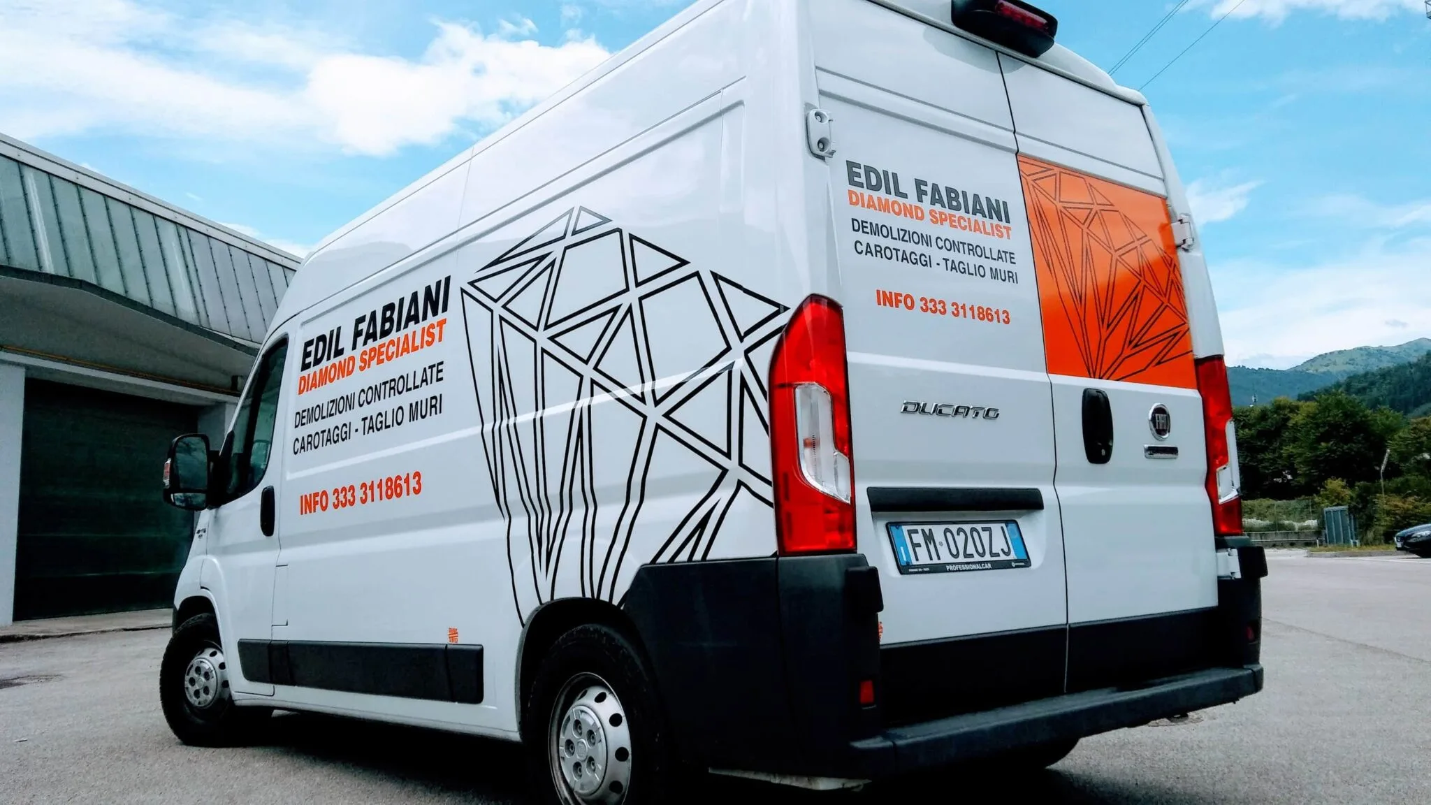 Furgone Edil Fabiani da dietro e di lato, con il diamante nero sulla fiancata e il portellone arancione