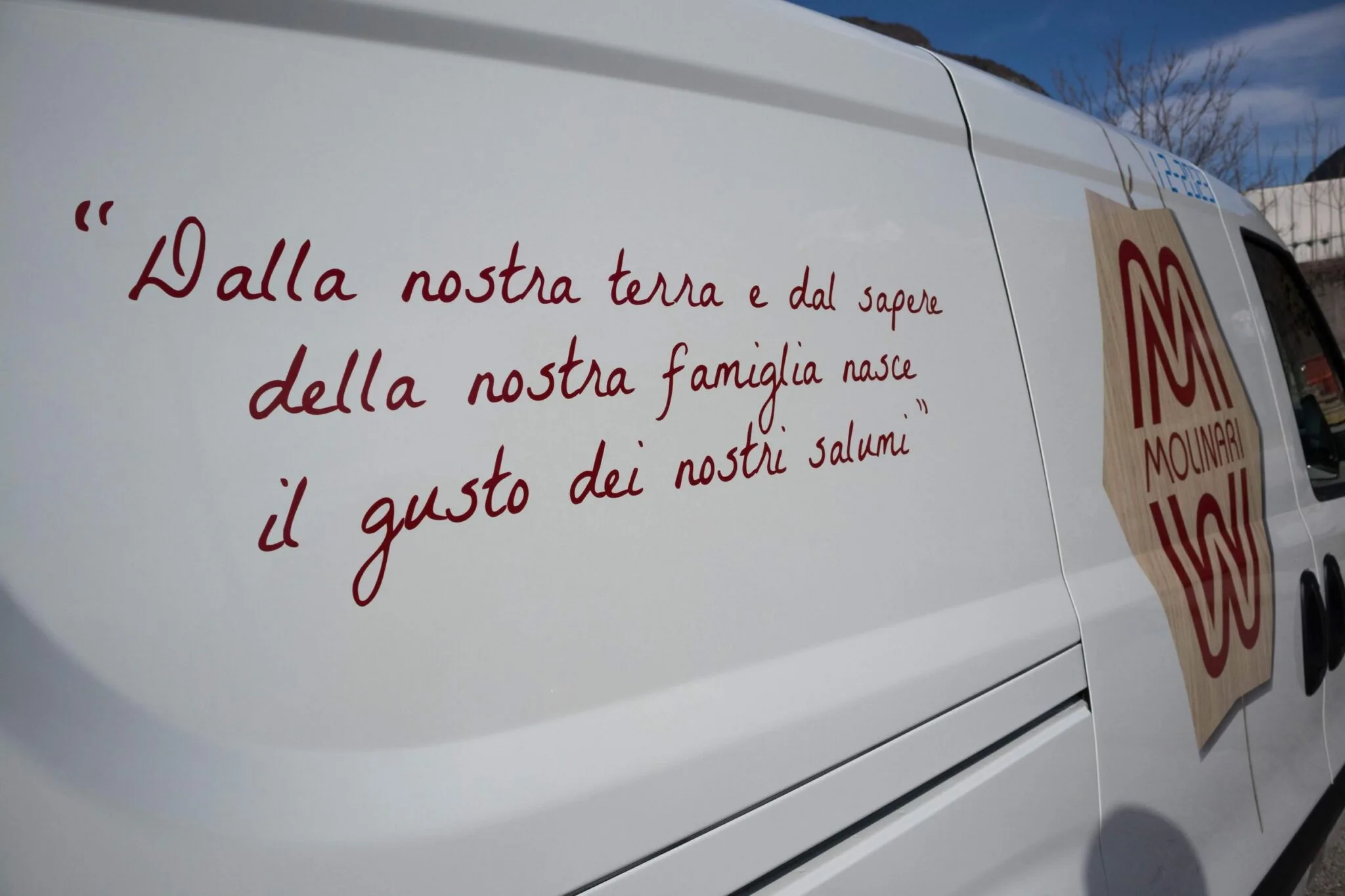 Frase manoscritta «Dalla nostra terra e dal sapere della nostra famiglia» adesiva sulla fiancata del furgone