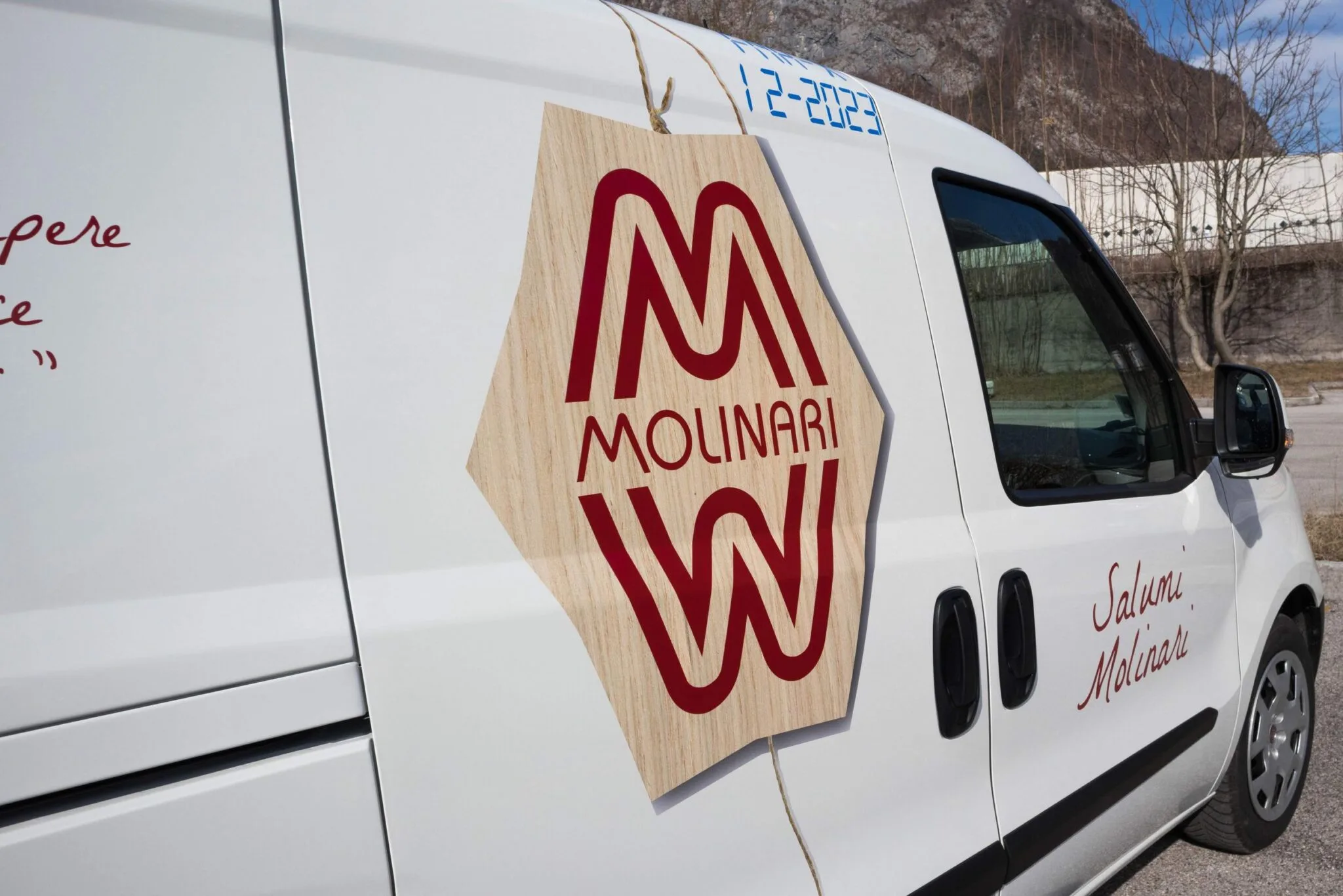 Logo Molinari a pentagono effetto legno applicato sulla fiancata del furgone, con scritta Salumi Molinari