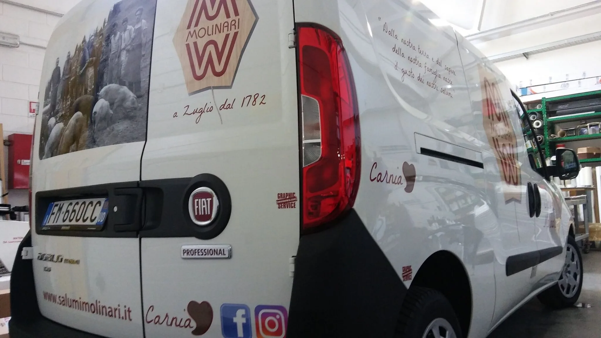 Dettaglio del retro del furgone Molinari con portellone, logo, indirizzo web e icone dei social in adesivo