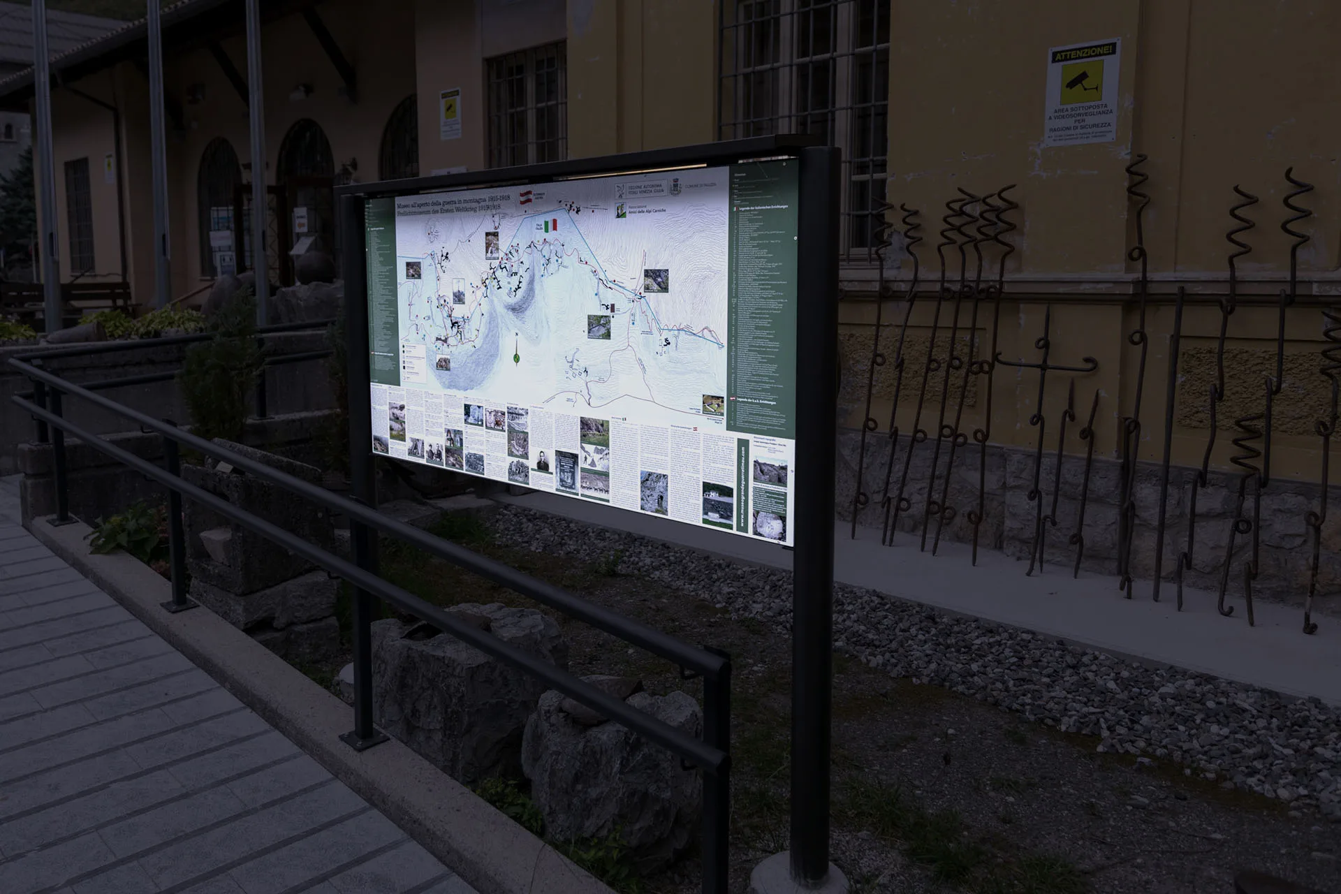 Stesso pannello con la mappa illustrata del territorio, visto al crepuscolo mentre è illuminato