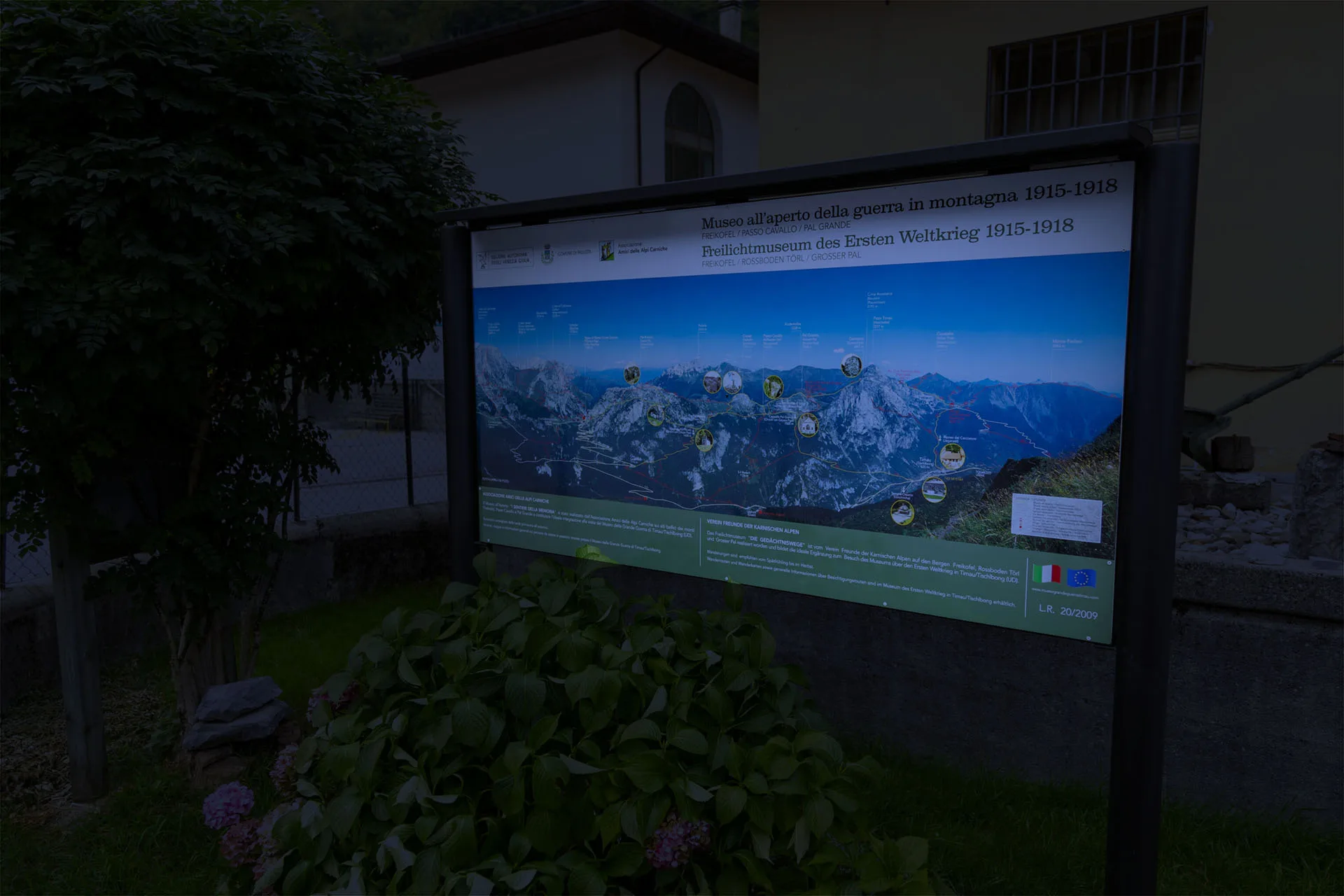 Bacheca con panorama delle Alpi illuminata nella penombra, con il cupolino che la protegge