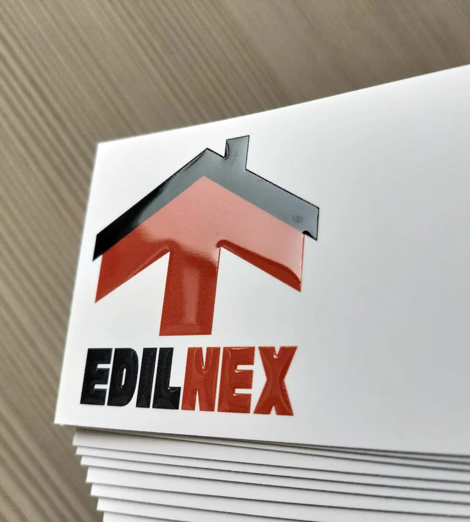 Il logo EdilNEX con la freccia rossa a forma di casa, in rilievo lucido sul fronte bianco soft touch del biglietto da visita