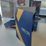 Cartellina portadocumenti blu e gialla di Prexta in piedi su una scrivania