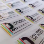 Etichette resinate di PAT termotecnica col logo, le righe colorate e i numeri di telefono, viste da vicino