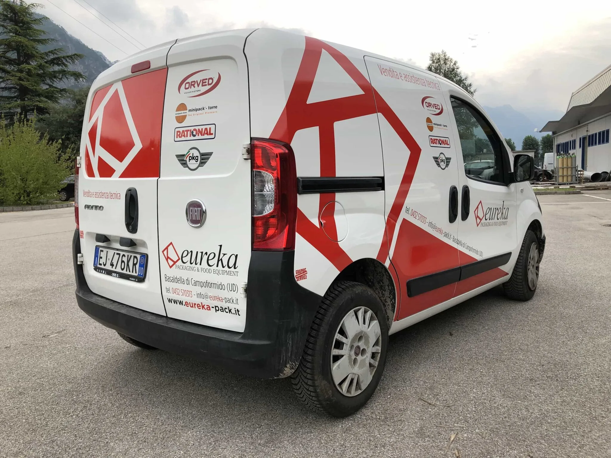 Furgone Eureka decorato con adesivi rossi e bianchi, visto da dietro sul lato destro