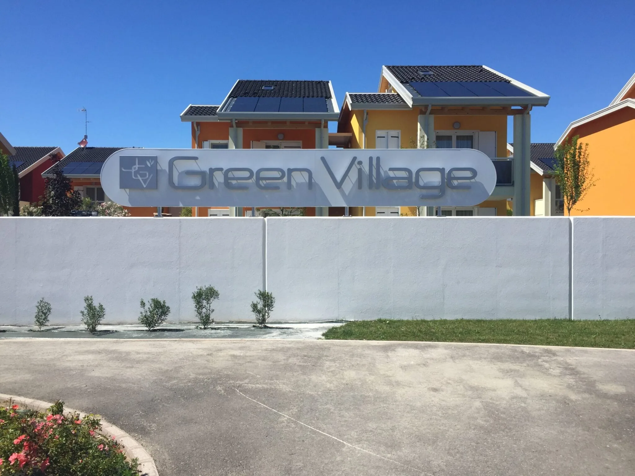 Insegna Green Village montata all'ingresso del villaggio turistico di Jesolo, sopra il muro bianco
