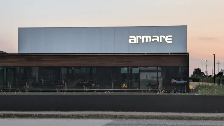 Il capannone di Armare a San Giorgio di Nogaro al tramonto, con il logo a lettere singole luminose