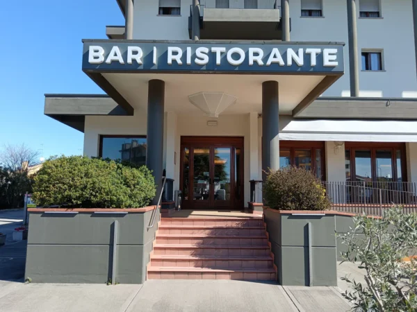 Insegna luminosa "Bar | Ristorante" a lettere scatolate sopra l'ingresso del locale