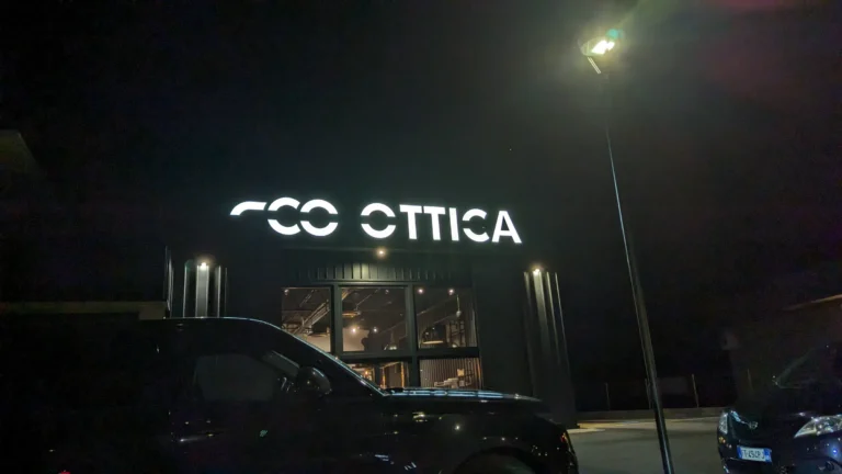 Insegna luminosa Comelstile a Buja di notte, lettere bianche a luce diretta