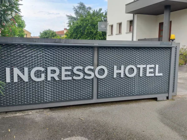 Insegna a lettere singole "Ingresso Hotel" su cancellata metallica