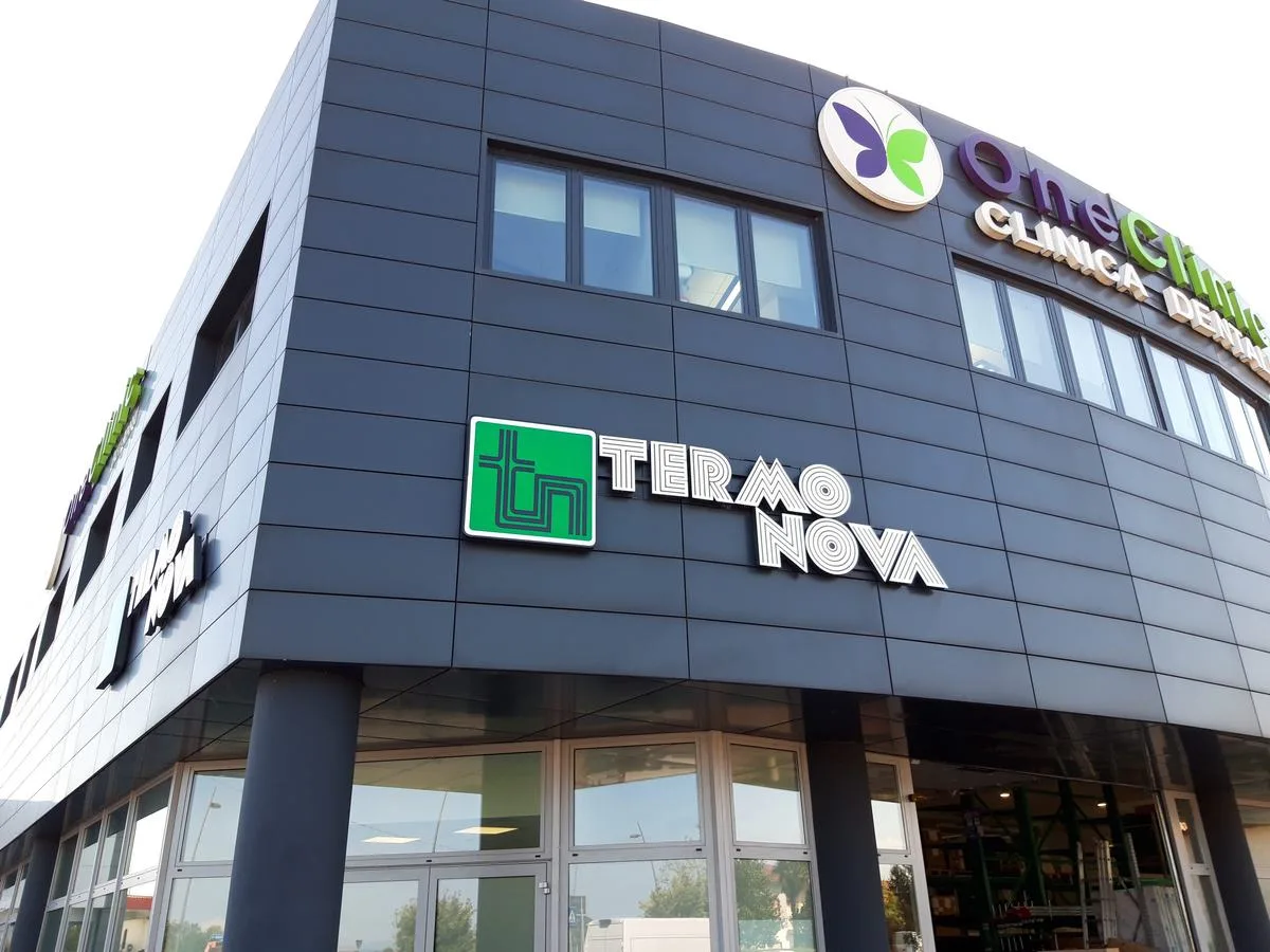 Lettere singole Termo Nova con logo verde, vista in prospettiva dell'angolo dell'edificio a Cervignano