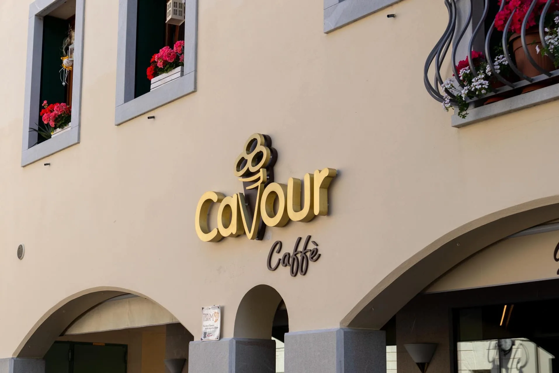 Insegna Cavour Caffè in ottone sulla facciata del palazzo, vista di giorno sopra i portici