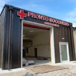 Insegna luminosa Pronto Soccorso con croce rossa a lettere singole sul nuovo ingresso ambulanze dell'ospedale di Tolmezzo