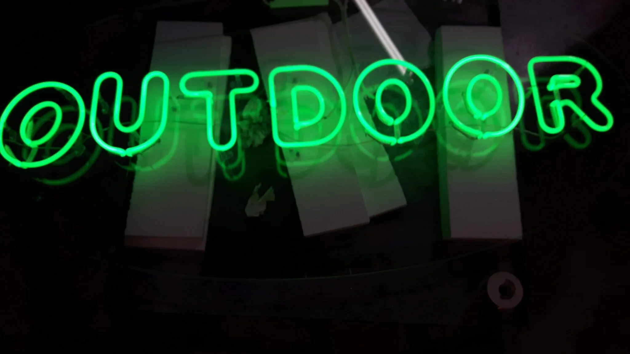 Scritta Outdoor al neon con tubo verde acceso, vista d'insieme in laboratorio