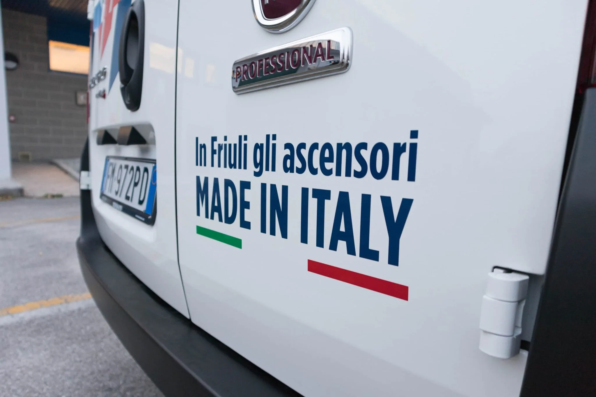 Scritta adesiva «In Friuli gli ascensori Made in Italy» sul portellone posteriore del furgone Modesto Ascensori
