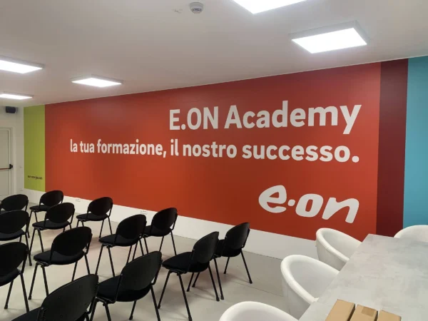 Parete rossa della sala corsi con la scritta E.ON Academy e il logo e-on, stampata su pellicola a San Daniele del Friuli