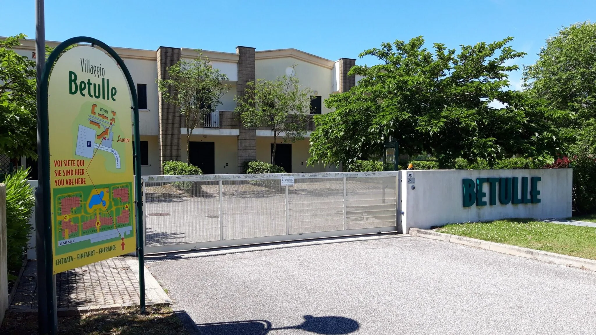 Cartello a mappa del Villaggio Betulle all'ingresso, accanto al cancello e alla scritta Betulle