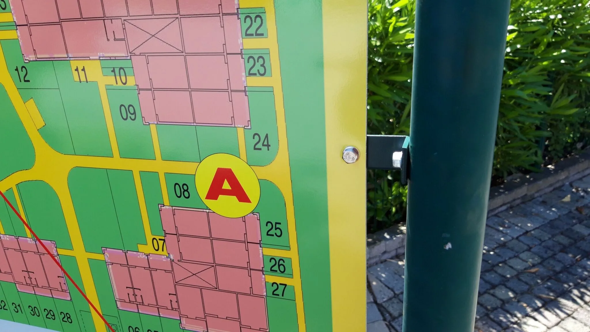 Dettaglio della mappa stampata e del fissaggio in acciaio inox sul palo verde del cartello