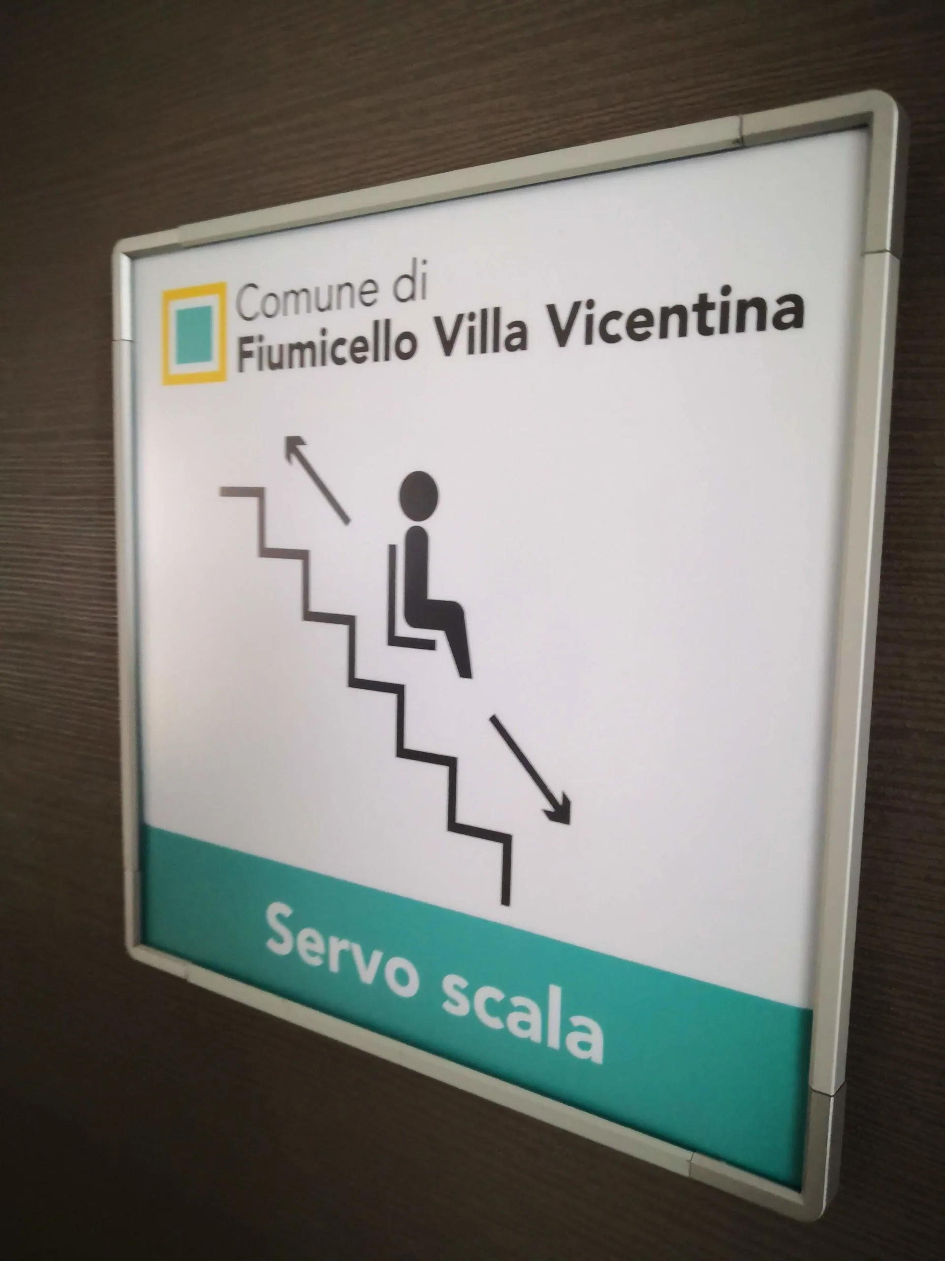Targa di segnalazione del servoscala nel municipio di Fiumicello Villa Vicentina