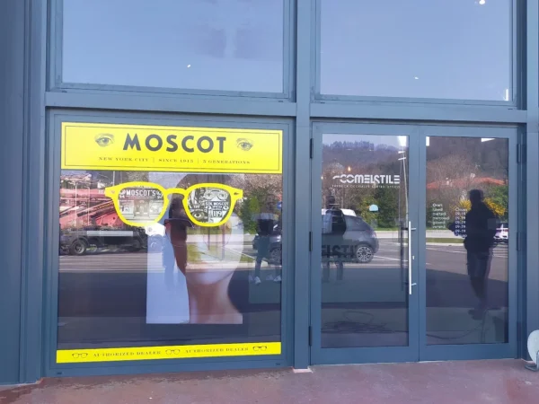 Vetrina con la vetrofania Moscot accanto alla porta d'ingresso di Comelstile a Buja