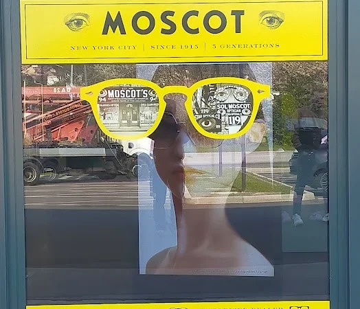 Vetrofania Moscot gialla con gli occhiali Lemtosh nella vetrina di Comelstile a Buja, stampata e posata da noi